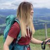 Wanderführerin Angelina ist im Wanderoutfit auf den Bergen unterwegs und lächelt. | © Angelina Holzer