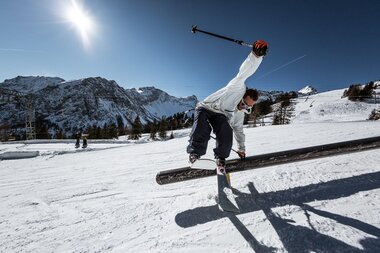 Cooler Trick auf eine Obstacle im Backyards Snowpark bei sonnenschein | © Backyards Snowpark