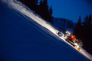 Schwarze Piste Brandnertal | © Bergbahnen Brandnertal, Michael Marte Ein roter PistenBully mit Windenseil präpariert eine schwarze Piste. | © Bergbahnen Brandnertal, Michael Marte