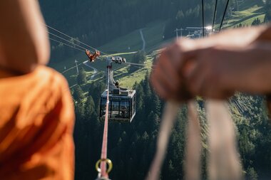 Gespanntes Seil | © Michael Kreyer Zwei Gondeln werden durch ein Seil verbunden. Das Seil ist im Fokus des Bildes. | © Michael Kreyer
